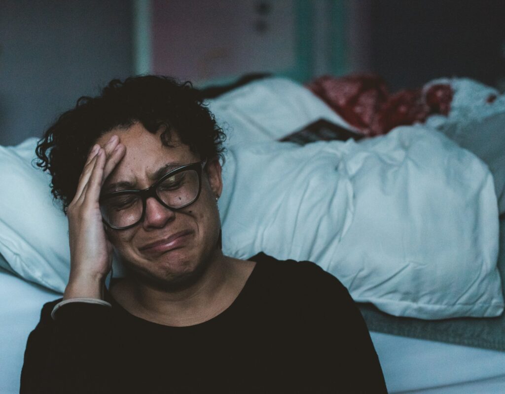 photo by claudia wolff person crying beside bed